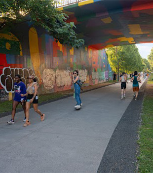 Sustainability 28 a group of people walking under a bridge